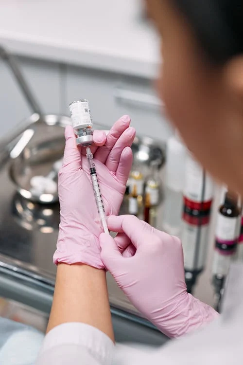 A doctor preparing a syringe for a medical injection