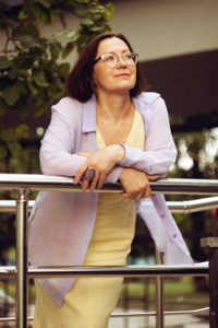 A middle-aged woman leaning on a railing