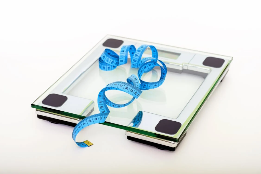 An image of a measuring tape on a transparent weighing scale