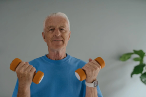An image of an elderly man holding 2kg dumb bells