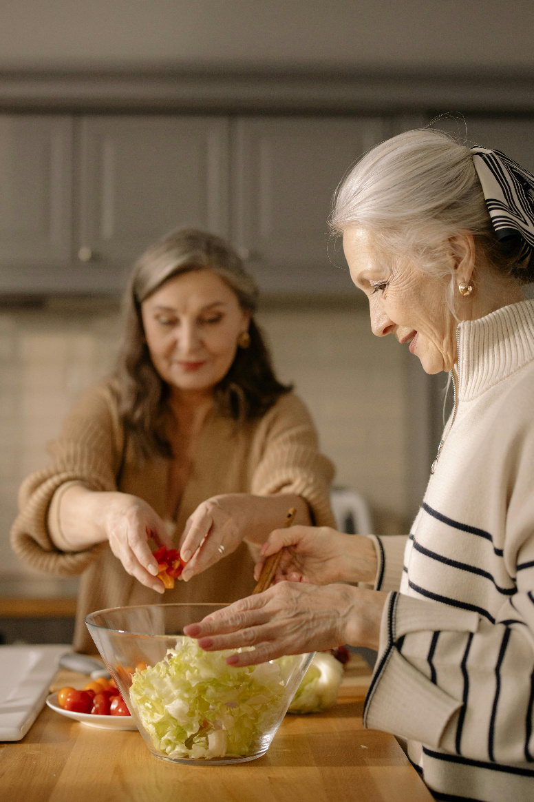 A picture of an elderly woman making salad