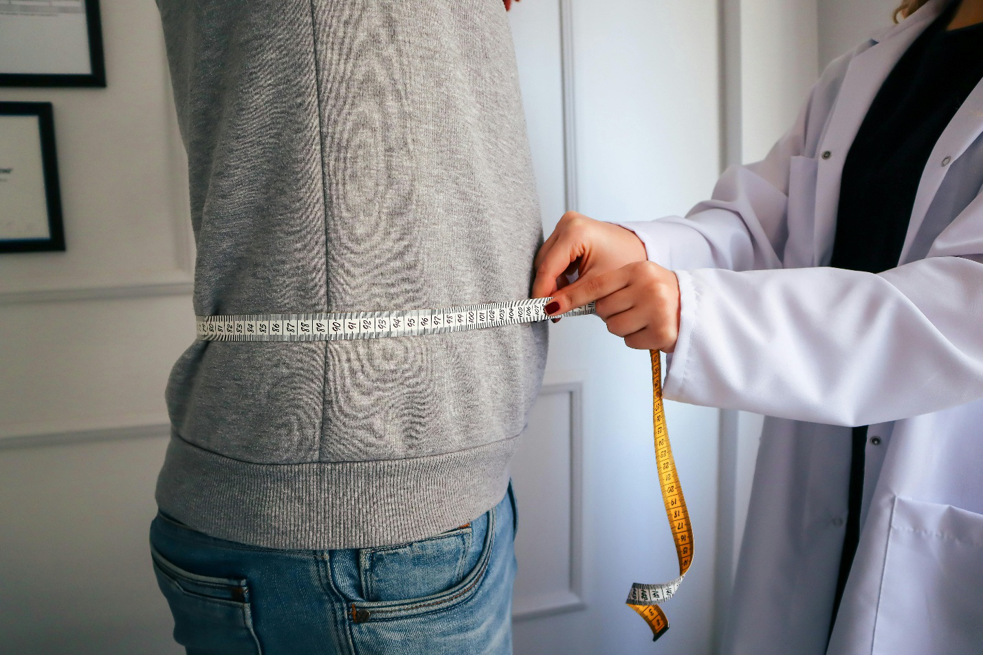 A doctor measuring a patient’s waist